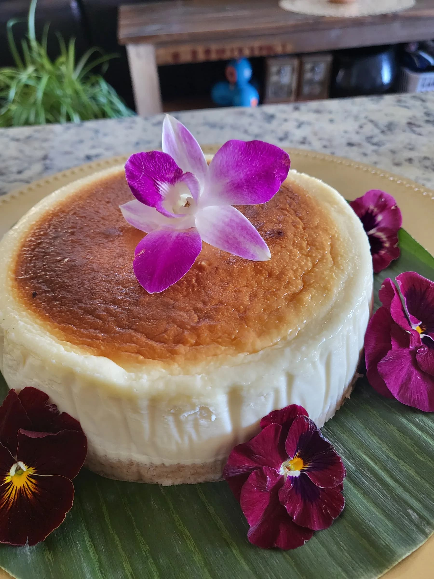 A baked custard topped with an orchid and pansies