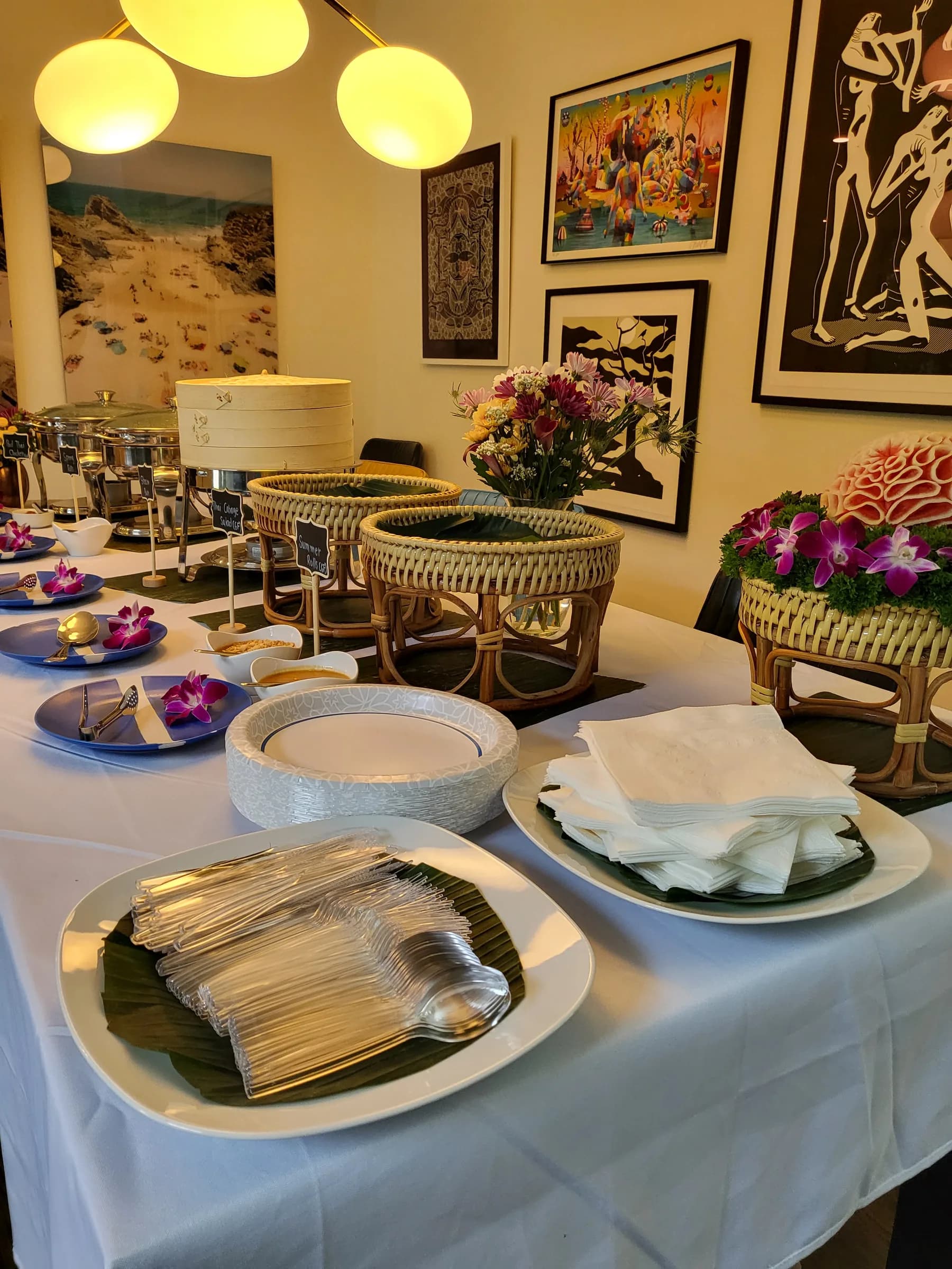 A buffet table with a carved melon centrepiece and orchids