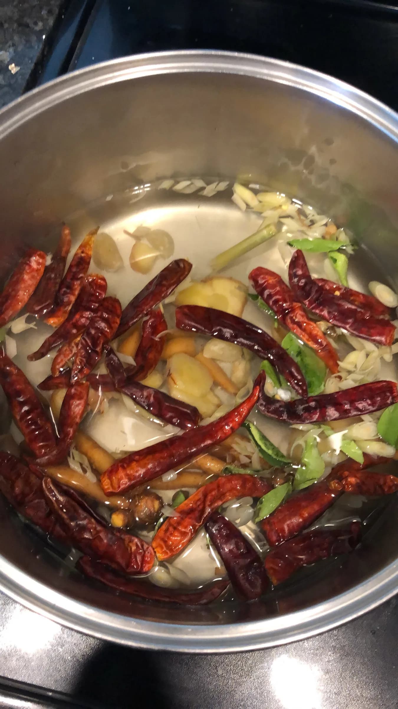 Dried chilies and garlic frying in a steel pan