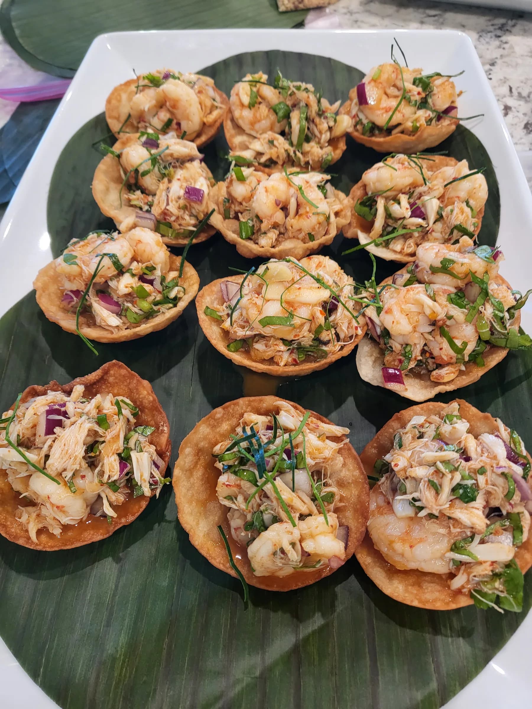 Shrimp salad served in crisp pastry cups on a banana leaf